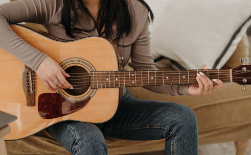 Woman Playing an Acoustic Guitar.