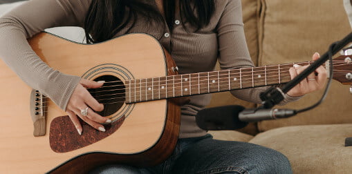 woman playing guitar with long nails