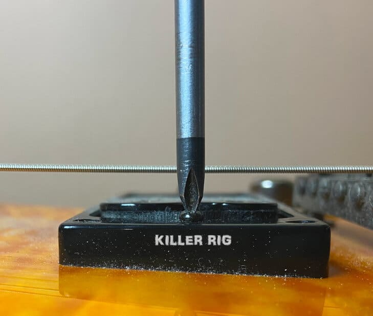 Guitar Pickup height Adjustment being made with a Screwdriver.